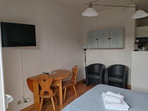 热拉梅普莱桑斯公寓酒店的配有桌椅和电视的客房
