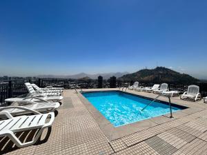 圣地亚哥Private apartment in Santiago的屋顶游泳池,带躺椅