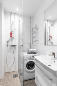 赫尔辛基Cozy, spacious and calm city home - top location的白色的浴室设有洗衣机和水槽。