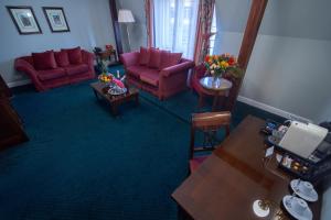 布拉格自由酒店的客厅配有2把红色椅子和桌子