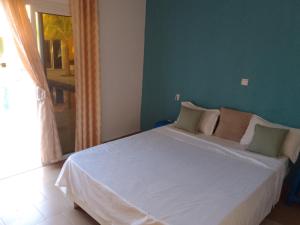 尼亚加Hôtel Colibri的一间卧室配有一张白色的床和绿色的墙壁