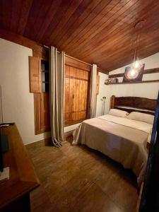 阿尤鲁奥卡Casa Portal Sagrado Matutu- Aiuruoca MG的一间卧室设有一张床和木制天花板