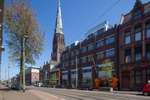 海牙easyHotel The Hague City Centre的教堂陡峭的,位于城市街道的中间
