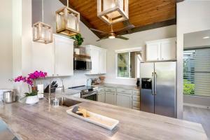 科纳CheCaHale: Gorgeous Top Floor Corner With AC的厨房配有白色橱柜和木制天花板