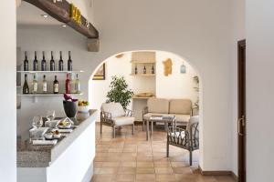 巴哈撒丁岛Hotel Sole Mare的一间品酒室,配有桌椅和葡萄酒瓶
