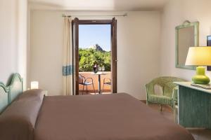 巴哈撒丁岛Hotel Sole Mare的一间卧室配有一张床,享有庭院的景色