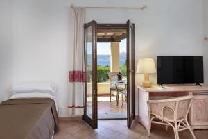 巴哈撒丁岛Hotel Sole Mare的一间卧室配有一张床和一张书桌及电视