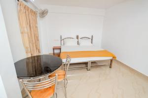 蒙纳EL LORA RESlDENCY的卧室配有一张床和一张桌子及椅子