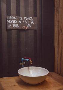巴拉斯港Casa loft con opción de tina temperada的墙上有标牌的桌子上的白碗