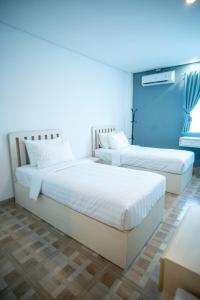 班达楠榜Elephant Inn and Suite by Sajiwa的蓝色墙壁客房的两张床