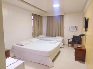 累西腓Hotel Boa Viagem Aeroporto的酒店客房设有两张床和电视。