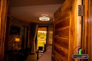 KirekaAmicus Hotel Kampala的一间设有木墙的客房和一间带窗户的客房