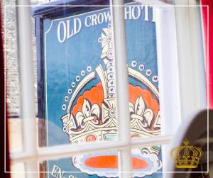 法灵登The Old Crown Coaching Inn的带有蓝色标志的窗户,上面有冠