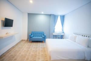 班达楠榜Elephant Inn and Suite by Sajiwa的一间卧室配有一张床和一张蓝色椅子