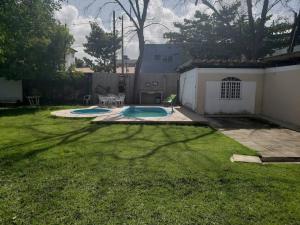 累西腓Casa com piscina aconchegante 300 m do mar的草地上带两个游泳池的院子