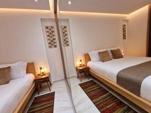 拉纳卡Sveltos Residence Suites的一间卧室设有两张床和两张台灯。