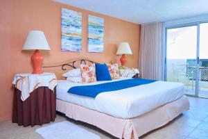 圣詹姆斯热带日落海滩公寓式酒店的一间带大床的卧室和一个阳台