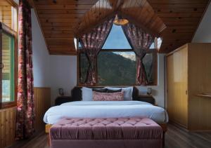 马拉里The Wooden Chalet, Manali by DBP的一间卧室设有一张大床和一个大窗户
