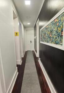 里斯本Samps Hostel的走廊上墙上有绘画,走廊上长