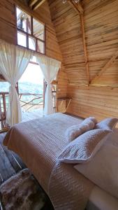 GiganteLos Nevados Ecolodge的小木屋内一间卧室,配有一张床