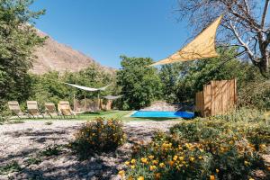 圣阿方索Cabaña de montaña (jacuzzi exterior)的风筝飞过带椅子和游泳池的院子
