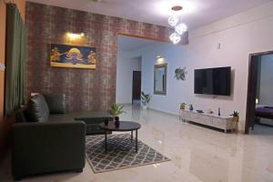 海得拉巴Veetil -3BHK A/C, Kukatpally, Hyderabad的客厅配有沙发和桌子