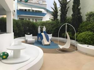 里乔内艾尔卡瓦利诺比安科酒店的建筑前方的庭院配有白色和蓝色家具