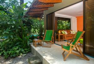 诺萨拉Olas Verdes Hotel的庭院设有两张绿色椅子和一张沙发