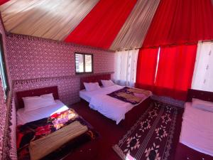 瓦迪拉姆Calm Camp的客房设有两张床和红色天花板。