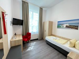 普雷罗Ferienhotel Alter Bahnhof garni的配有一张床和一张书桌的酒店客房