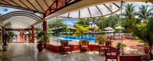 塞古罗港Resort Arcobaleno All Inclusive的一个带游泳池和桌椅的度假酒店
