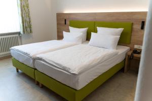 西梅尔恩博尔格施洛申酒店的一间卧室配有一张大床和绿色床头板