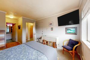 新港The Big View的一间卧室配有一张床、一张桌子和一台电视。