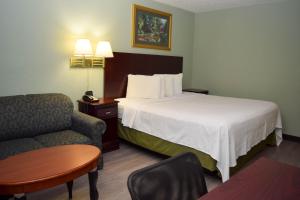 佩恩提德波斯特康宁酒店的配有一张床和一把椅子的酒店客房
