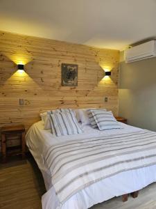 安东尼奥港Hotel Bacaris的卧室配有一张白色大床和木墙