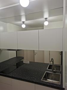 贝尔格莱德BG Exclusive Apartment的厨房配有黑色台面和水槽