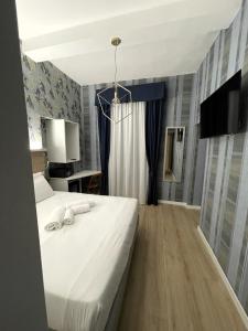 罗马ROME'S GLORIA HOTEL的卧室配有白色的床和电视。