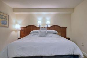 默特尔比奇2501 S Ocean Blvd, 1115 - Ocean View Sleeps 8的一间卧室配有一张带两盏灯的大型白色床。