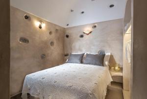 安坡里奥圣托里尼Luxury Villas Hariton的一间卧室配有一张带白色床罩的床