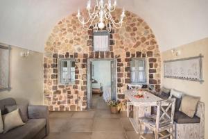 安坡里奥圣托里尼Luxury Villas Hariton的客厅配有桌子和石墙