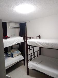 坎昆Naranjo Hostel的一间设有三张双层床和一盏灯的房间