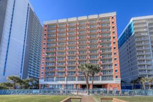 默特尔比奇1604 N Ocean Blvd, 0703 - Ocean Front Sleeps 6的一座高大的公寓楼,前面有一棵树