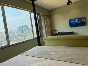 孟买Hotel Mumbai House, Malad的一间卧室设有一张床和一个大窗户