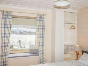 BrynsiencynSea Front Spacious Apartment on Anglesey的一间卧室设有水景窗户