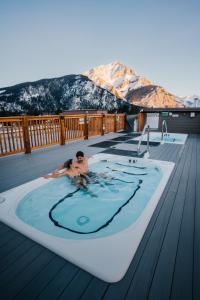 班夫Basecamp Suites Banff的甲板上热水浴池里的人