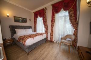 伊斯坦布尔BeyPort Hotel Taksim的一间卧室配有一张床、一把椅子和窗户。