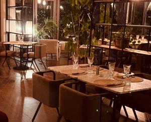 卢恰纳Hôtel Spa Restaurant La Madrague的一间设有桌椅的餐厅,种植了植物