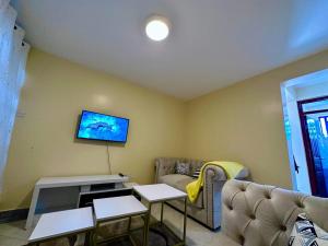 ThikaCandy's Staycation的客厅配有沙发和墙上的电视