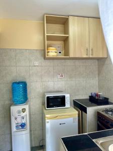 ThikaCandy's Staycation的厨房配有冰箱上方的微波炉