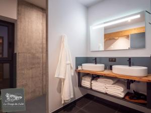圣莫里斯堡La Grange des Eulets的浴室设有2个水槽、镜子和毛巾。